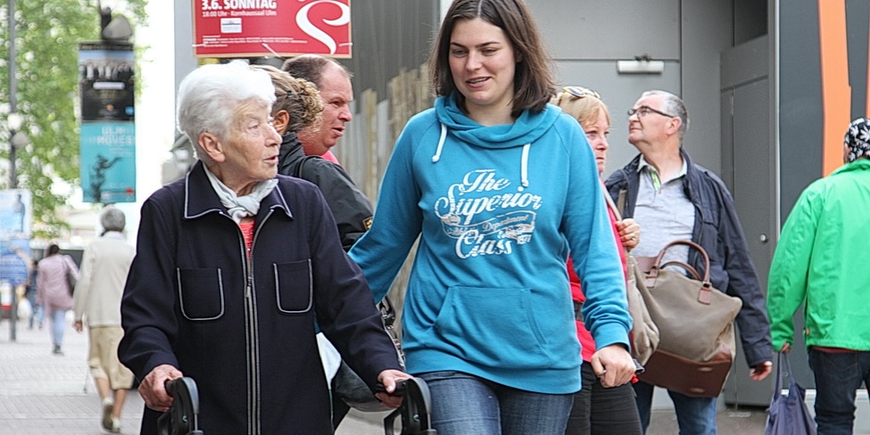 Ältere und jüngere Frau gehen im Quartier spazieren